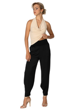 Load image into Gallery viewer, Woman wearing a beige halter top and black pants on a white background