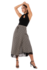 Load image into Gallery viewer, Woman wearing a black top and patterned wide-leg pants on a white background