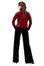 Load image into Gallery viewer, Woman wearing a red velvet top and black pants on a white background