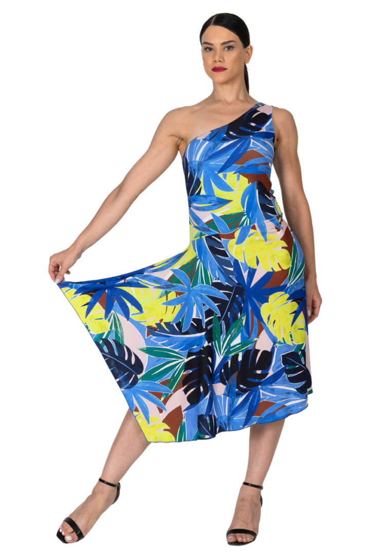 Woman wearing a colorful one-shoulder dress with a leaf pattern on a white background