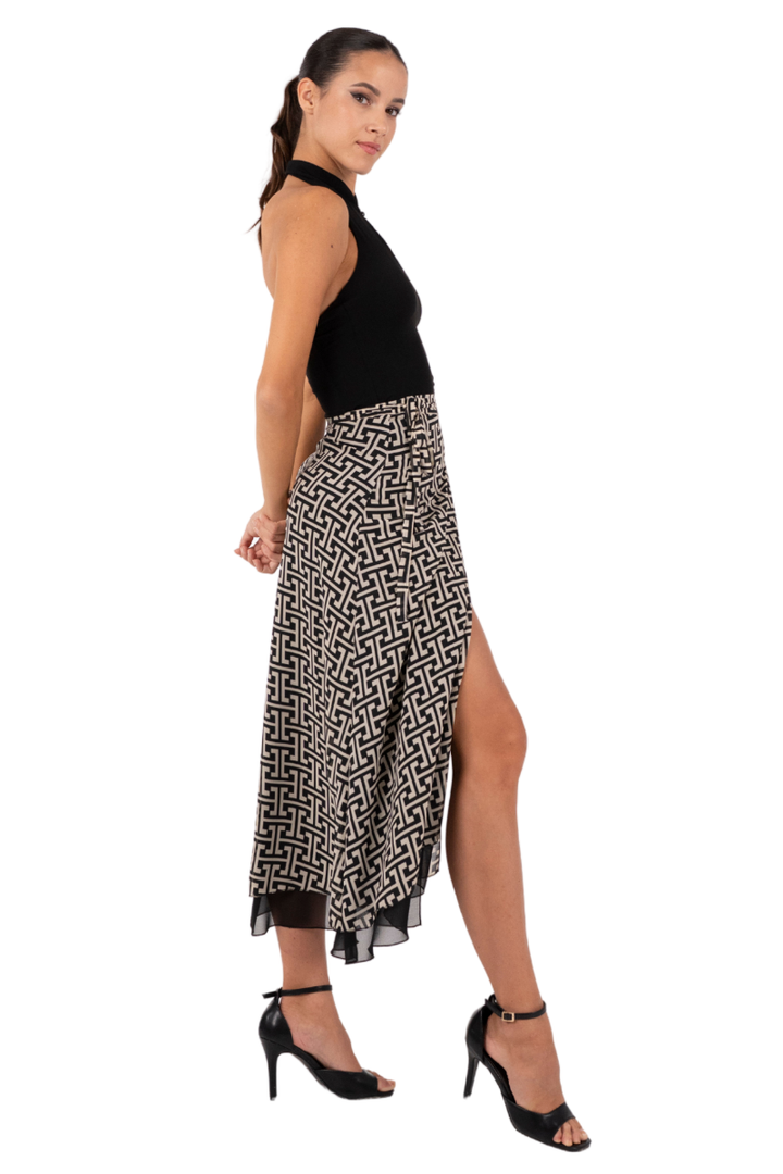 Woman wearing a black top and patterned skirt on a white background