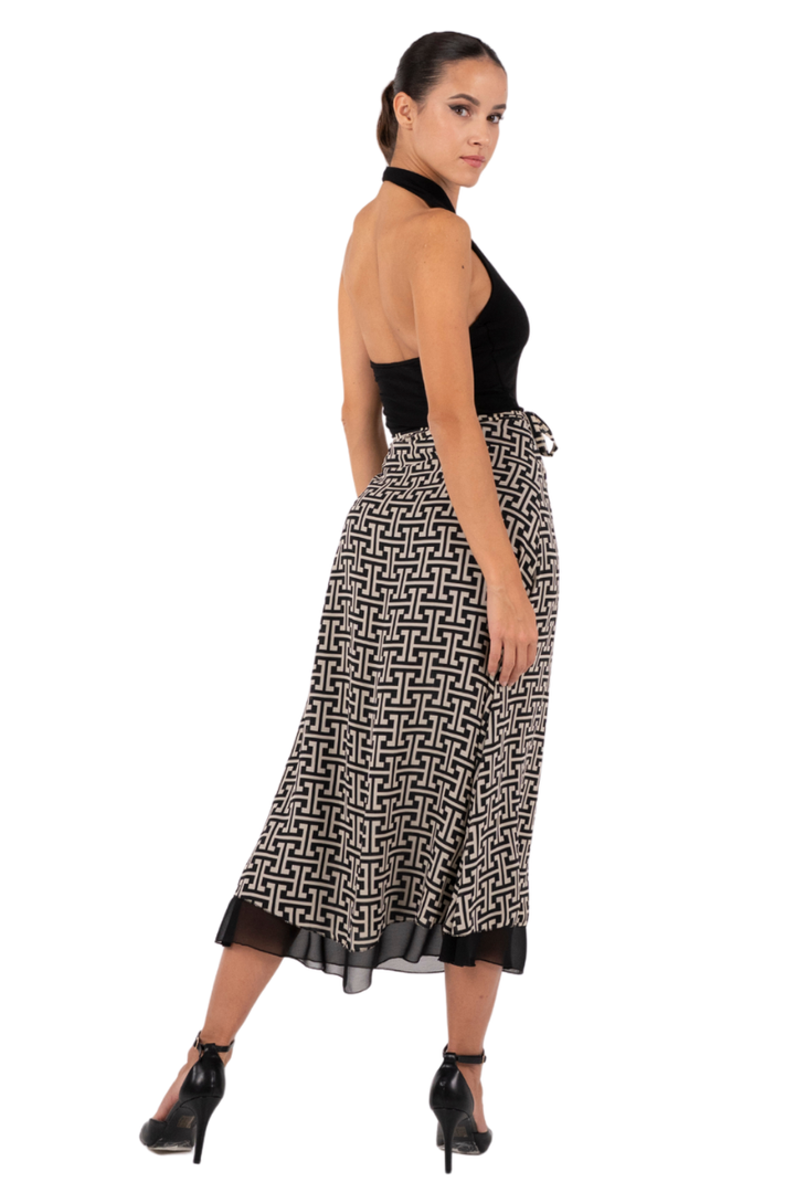 Woman wearing a black halter top and patterned skirt on a white background