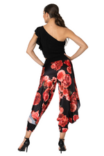 Load image into Gallery viewer, Woman wearing a black top and red floral pants on a white background
