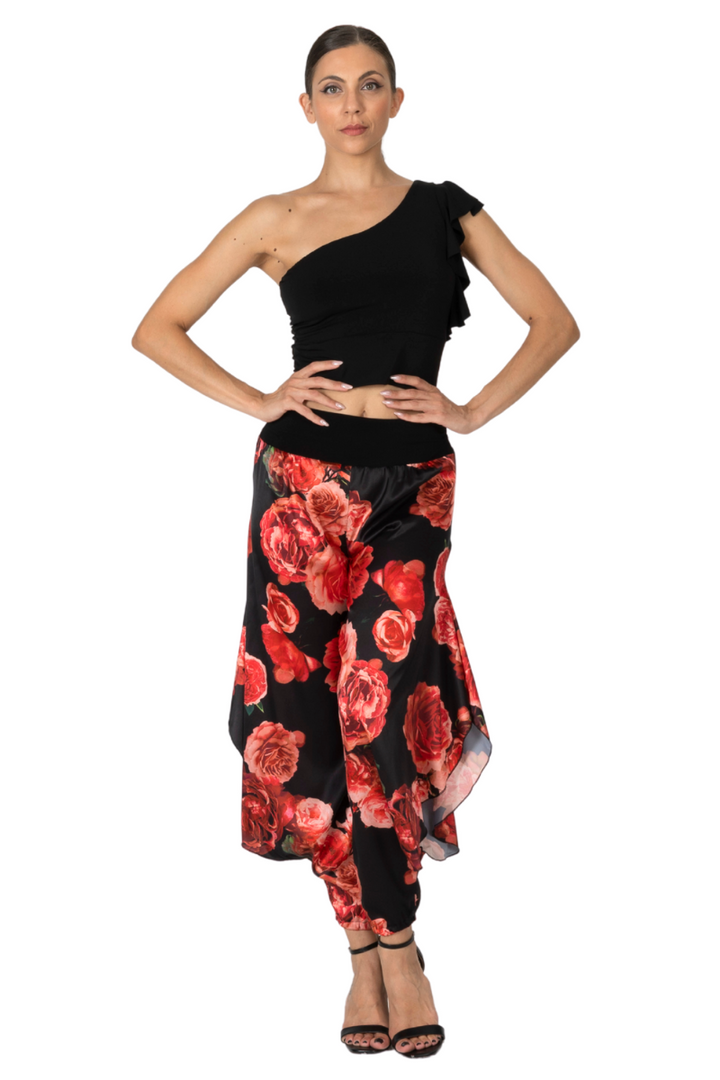 Woman wearing a black one-shoulder top and red floral skirt on a white background